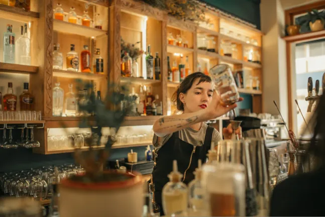 Young,Female,Bartender,Standing,Behind,The,Counter,Of,A,Trendy